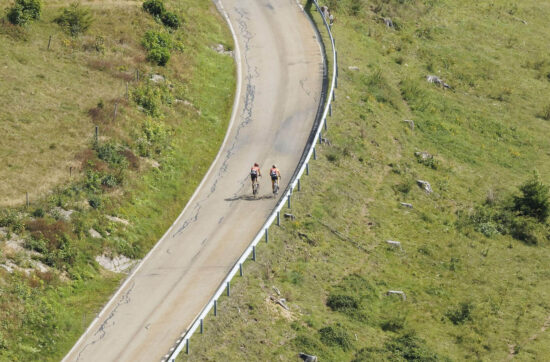 Zwei Radfahrer genießen eine Fahrt auf einer ruhigen Straße.